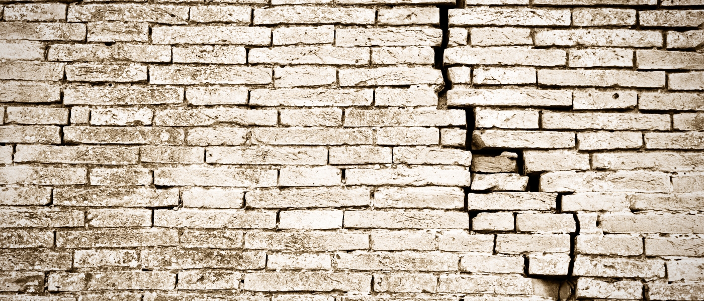 Brick wall with a substantial crack all the way through