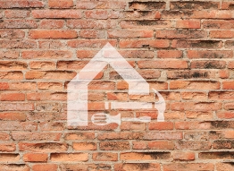 Brick wall with the Agency house logo and some tools