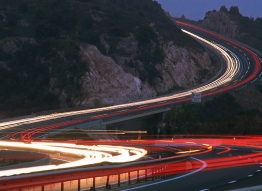 A time delayed photograph of a highway and cars on a mountain side
