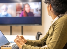 Photo of a woman in front of a computer participating in a virtual meeting